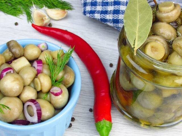 Домашні мариновані помідори з часником та зеленню: хрустка заготовка на зиму без оцту